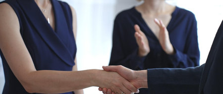 Business executives shaking hands during a successful corporate meeting, finalizing an important...