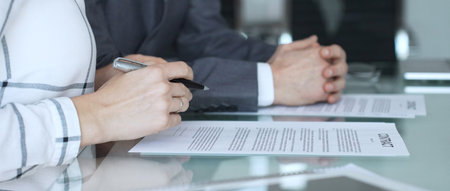 Business people reading and discussing contract terms, financial agreement, and legal paperwork...