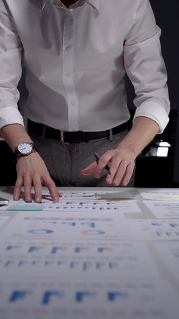 Professional businessman working late nights in office, analyzing financial data and statistics,...