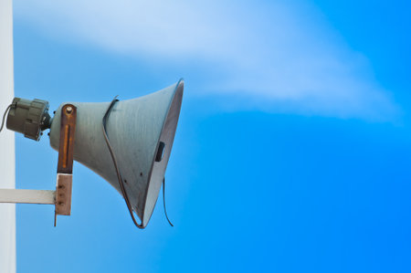 Old loudspeaker against cloudy blue sky の写真素材