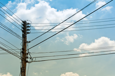 Electrical post with power line cables against blue sky の写真素材