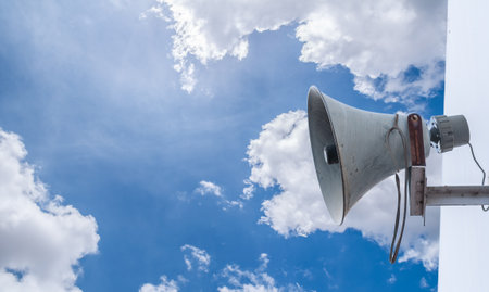 Old loudspeaker against cloudy blue sky の写真素材