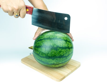 Watermelon and knife placed on a white background.の写真素材