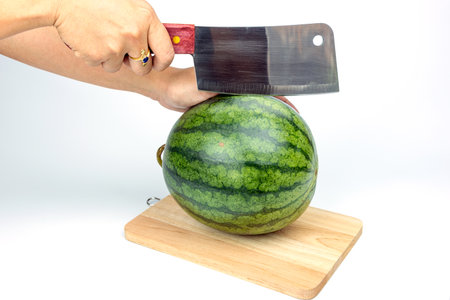 A watermelon and a knife is placed on a white background.の写真素材