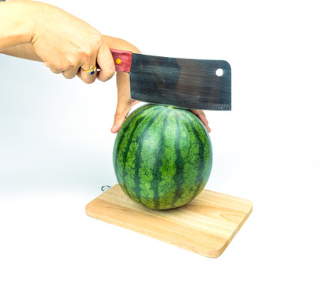 A watermelon and a knife is placed on a white background.の写真素材