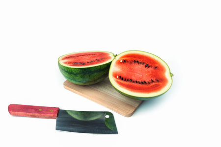 A cut watermelon and a knife is placed on a white background.の写真素材