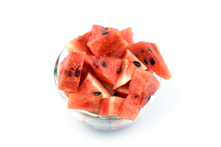 Cut watermelon in a bowl placed on a white backgroundの写真素材