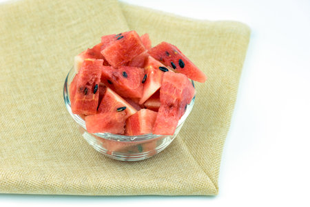 Cut watermelon in a bowl placed on a white backgroundの写真素材