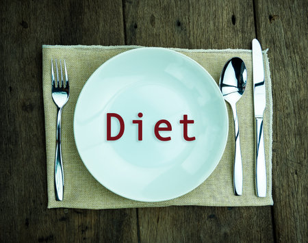 Placing a spoon on a plate at a dining table.dietの写真素材