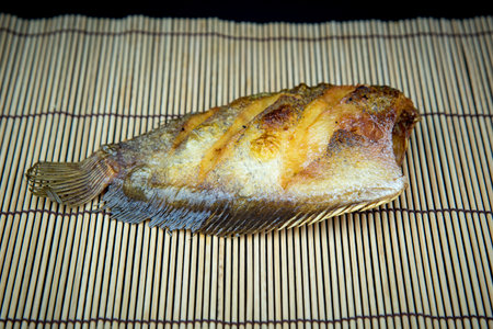 Fried fish cooked and placed on old wooden floor.の写真素材