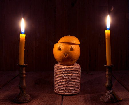 Orange Devil Halloween with candle on old wooden floorの写真素材