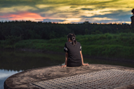 Lonely woman dreaming and looking at beautiful sunsetの写真素材