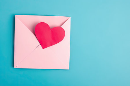 Pink envelope with a heart, empty copy space, blue background, valintines day greeting card, romantic mail, love letterの素材