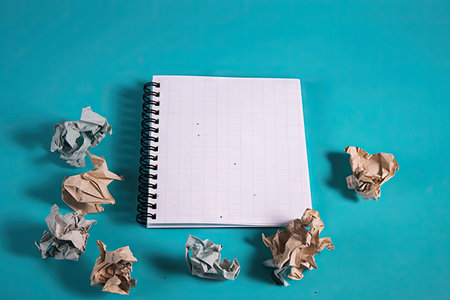 Empty notebook with paper crumbles around, blue colored background, copy space, new idea, brainstormingの素材