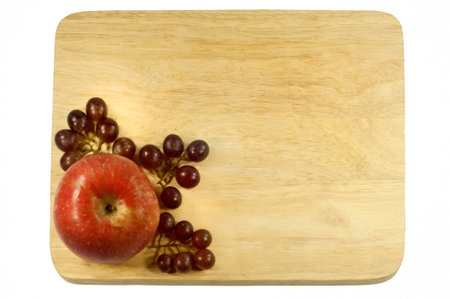apple and grapes on wood plate backgroundの写真素材