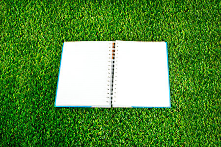 notebook on green grass backgroundの写真素材