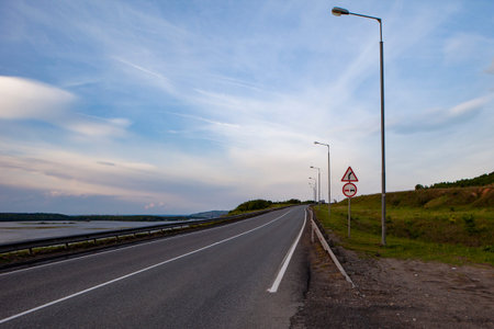 An empty road with lanterns on the shore of the great Volga river.