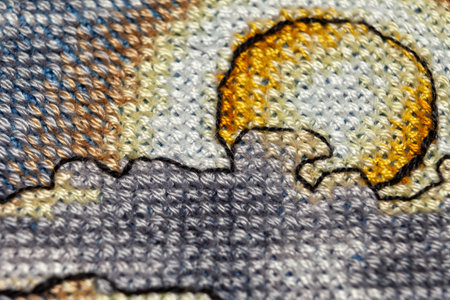 Cross-stitch. Macro photography of embroidery sites. Shooting with a small bluff of sharpness. Bright patterns on the canvas.の写真素材
