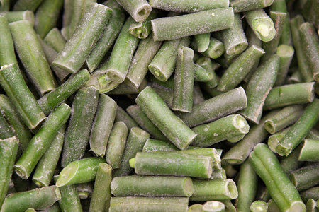 Texture of frozen sliced green asparagus beans in a shop. Asparagus in icy glaze. Diet vegeterian...