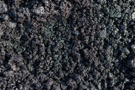 Texture of fresh hot asphalt. Black background resembling anthracite. Smolyanisty flashing intense...