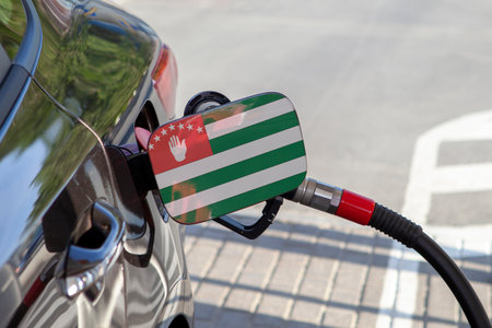 Flag of Abkhazia  on the car's fuel tank filler flap. Fueling car with petrol pump at a gas station. Petrol station. Gasoline and oil products. Close up.の写真素材