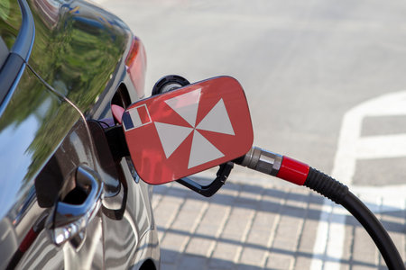 Flag of Wallis on the car's fuel tank filler flap. Fueling car with petrol pump at a gas station. Petrol station. Gasoline and oil products. Close up.の写真素材