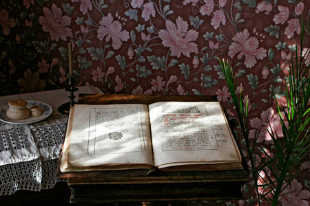 Sizran, Russia, February 10, 2005: Museum, interior of the merchant's living room. Old book with russian text. Floral wallpaper, candle.のeditorial素材