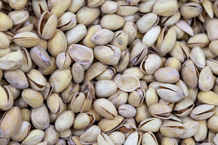 Unrefined pistachios in shell on market counter in daylight. Fresh nuts in macro photo. Close up. Top view.の写真素材