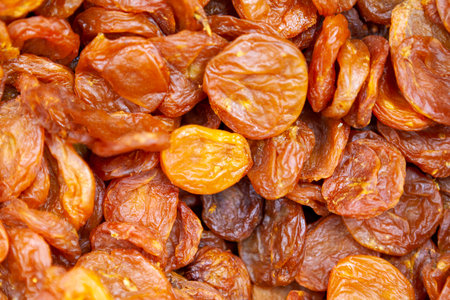 Dried apricots texture in shop close up. Large pile of dried apricots, dried fruits, healthy dessert, vegetarian food.の写真素材