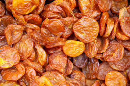 Dried apricots texture in shop close up. Large pile of dried apricots, dried fruits, healthy dessert, vegetarian food.の写真素材