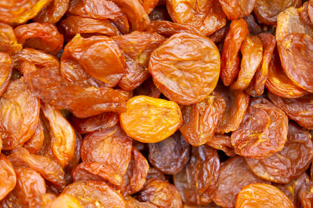 Dried apricots texture in shop close up. Large pile of dried apricots, dried fruits, healthy dessert, vegetarian food.の写真素材