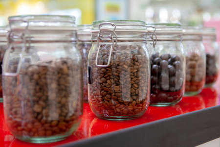 Coffee beans in glass jars on the cafe counter. Bright colors of taste.の写真素材