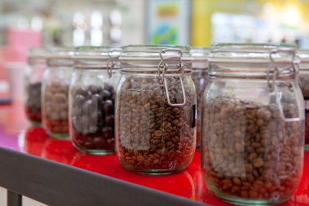 Coffee beans in glass jars on the cafe counter. Bright colors of taste.の写真素材