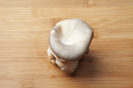 Fresh oyster mushroom clusters laid out on a natural bamboo cutting board. Delicious delicacy giving a special taste to many dishes.の写真素材