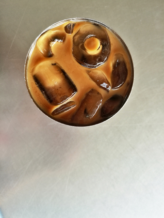 A stainless steel glass of ice coffee on the tableの写真素材