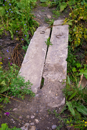 bridge of two concrete blocks across a shallow ditchの写真素材