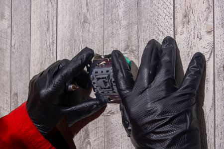 electrician installs an electric light switch on the wall