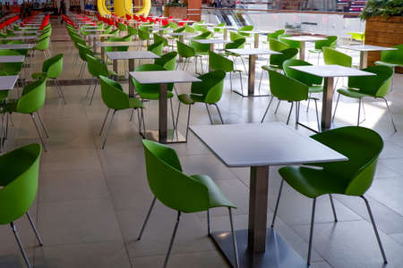 a few empty green tables on the food court at the mallの写真素材
