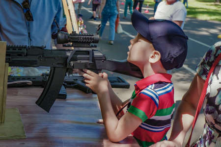boy shoots air rifle in street shooting range.の写真素材