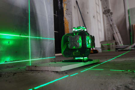 the laser level stands on the floor and draws levels for the installation of building materials,の写真素材