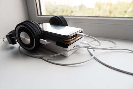 cell phone and headphones are charged using powerbank.の写真素材