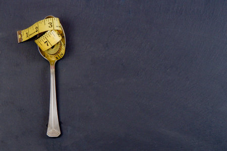 the tailor's meter lies in a spoon on the table. the concept of dietary nutrition.the concept of weight control,の写真素材