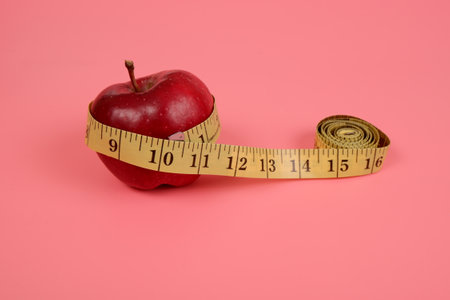 the tailor's meter is wrapped around an apple.the concept of healthy eating.the concept of weight control.の写真素材