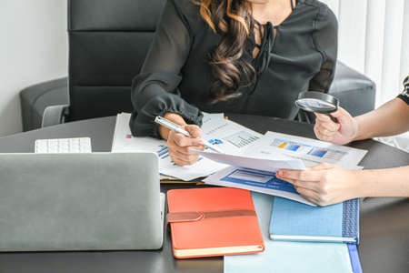 Resume or Recruitment. Businesswoman and partner examining or analyzing resume documents on desk at the office. Business success concept.の写真素材