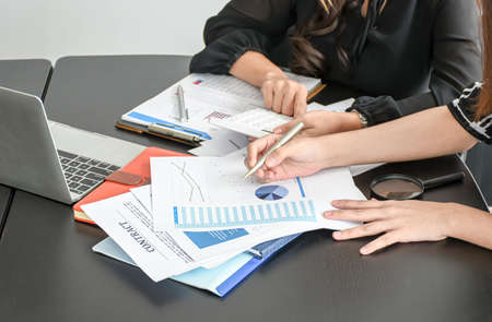 Businesswoman and partner examining or analyzing resume documents on desk at the office.の写真素材