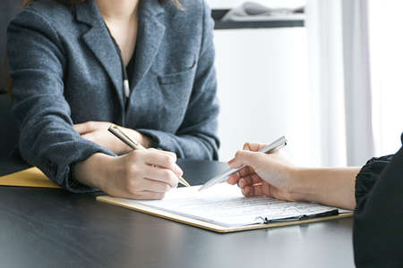 Two businesswomen partner signing contract a document.の写真素材