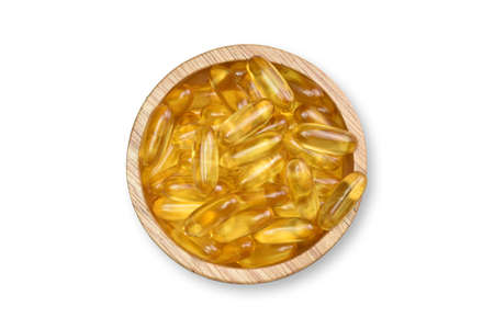 Clipping Path. Top view(Flat lay) of Supplementary food. Gold Salmon Fish oil capsules on wood bowl isolated on white background. Omega 3. Vitamin D and E.の写真素材