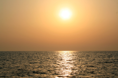 Beautiful sunrise cloudscape over ocean background. Sun rays beaming through picturesque clouds above seaの写真素材