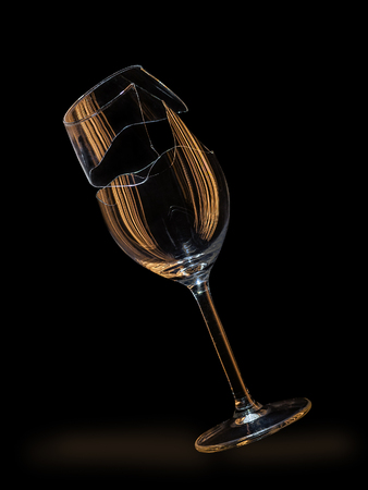 Falling broken wine glass illuminated with traces of light, on black backround, with pathの写真素材