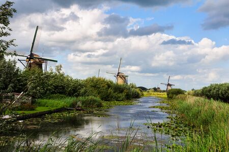 Dutch lanscape with three old windmills at the river.の写真素材